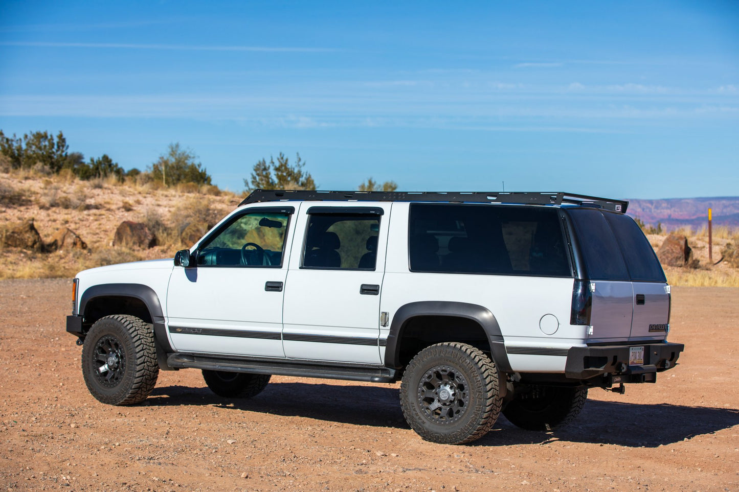 1992-1999 Chevrolet Suburban with roof rack  and Winch Bumper from Baseline Overland. rear side view with chassis unlimited rear octane bumper